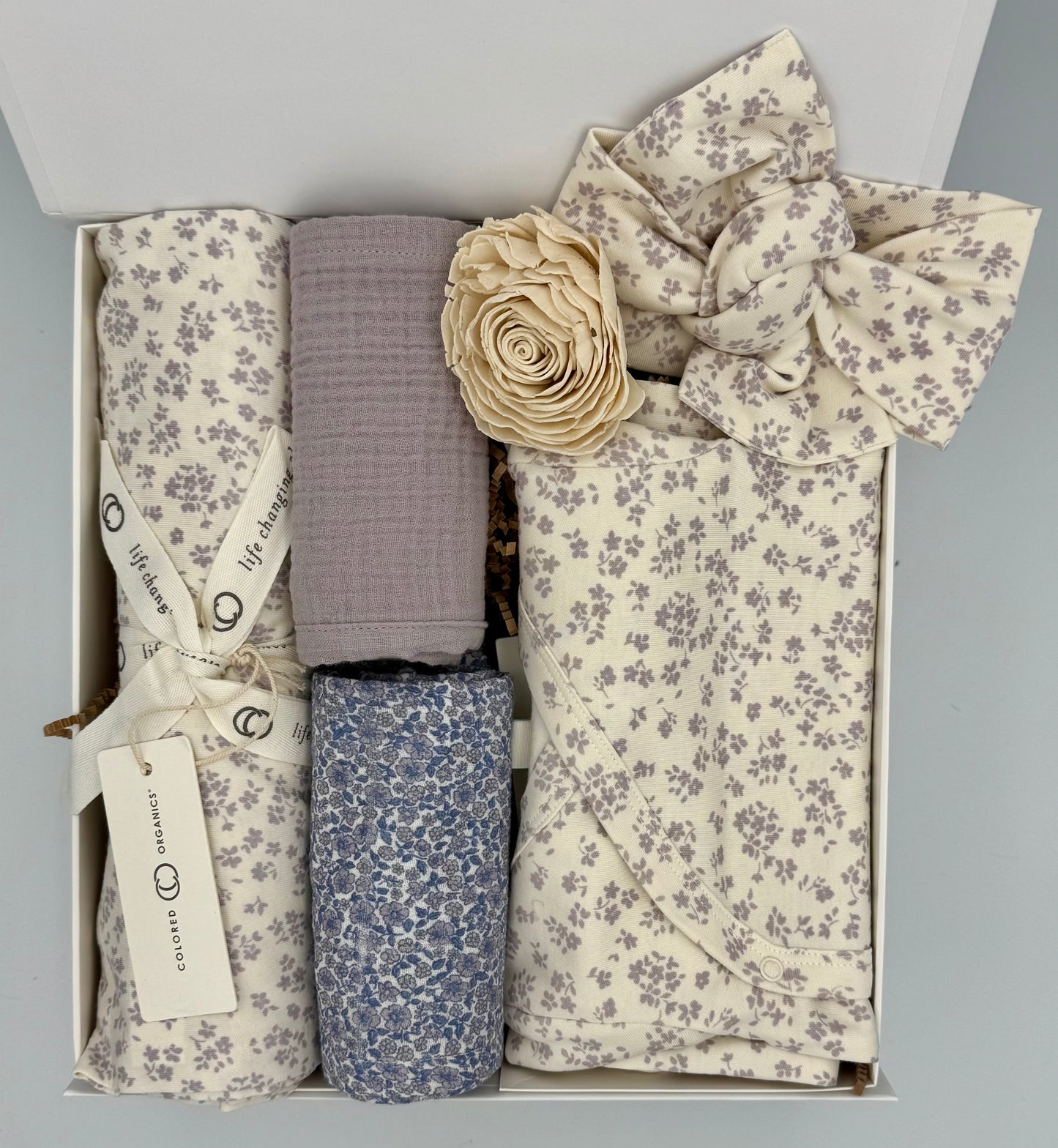 Set of baby blankets and headbands in a box with floral patterns.