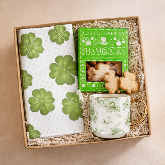 Gift set with shamrock-themed towel, mug, and cookies in a box