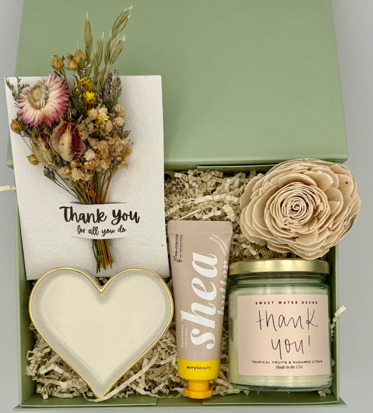 Gift set with candle, lotion, heart-shaped dish, and dried flowers in a box.