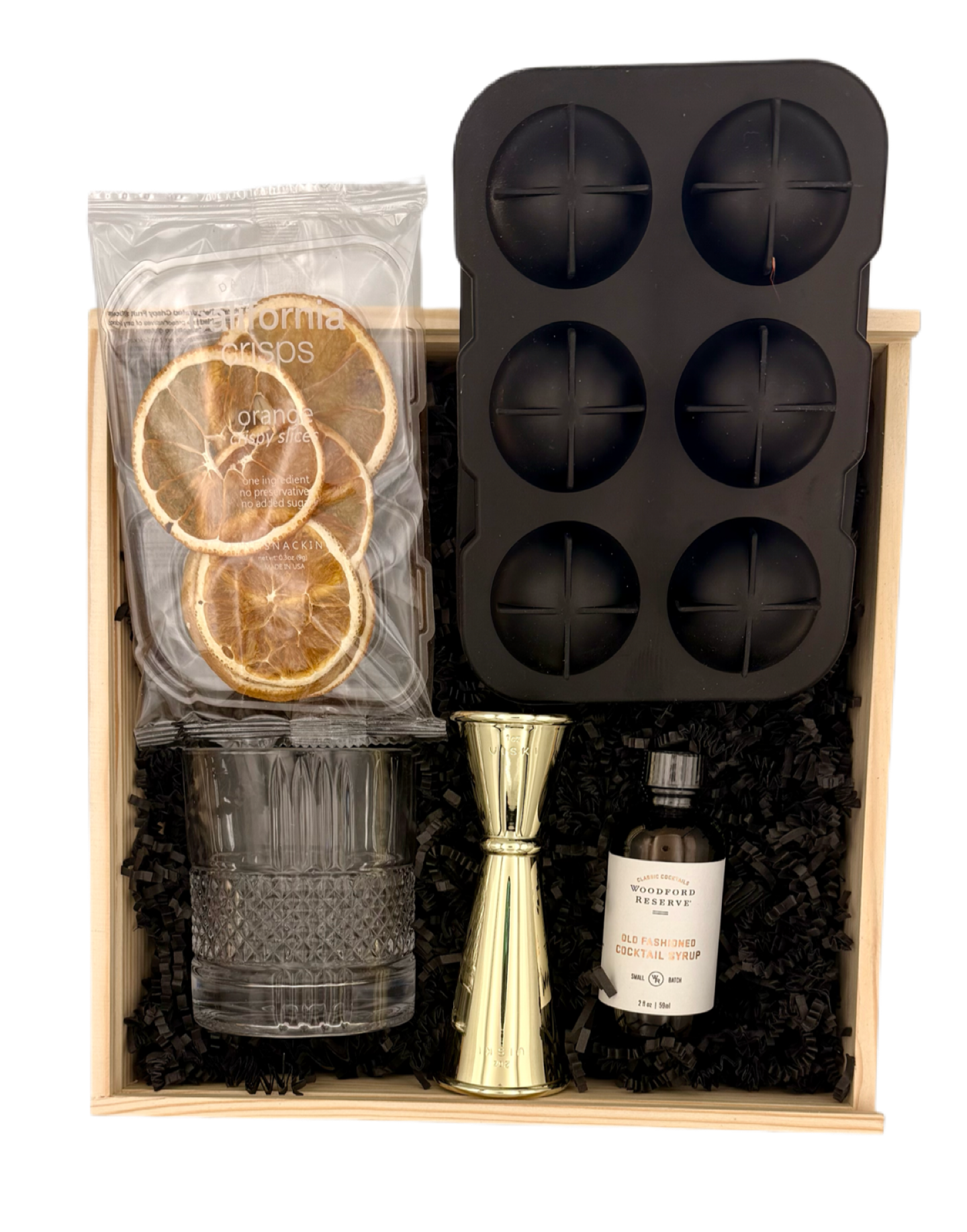 Gourmet gift set with ice cube tray, glass, jigger, and bottle in a wooden box.
