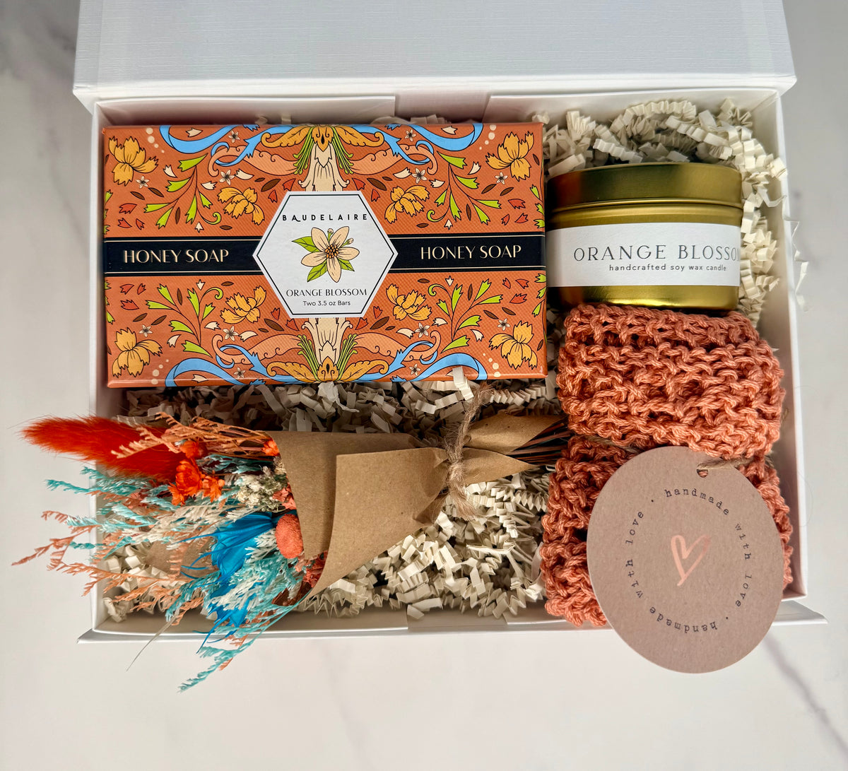 Gift set with soap, candle, and decorative elements in a box