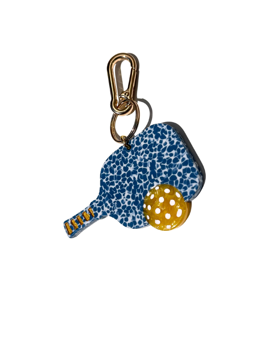 Keychain with blue speckled paddle and yellow ball on a white background