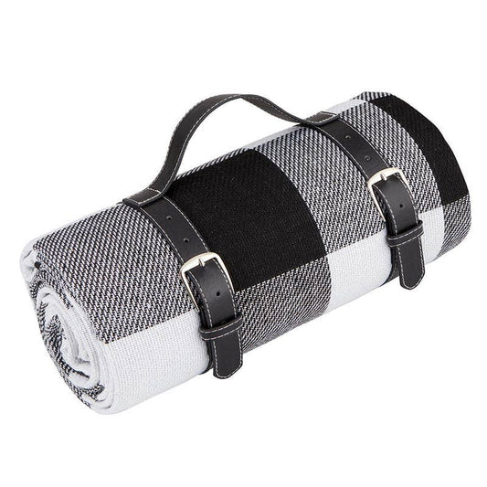 Roll-up picnic blanket with black straps on a white background