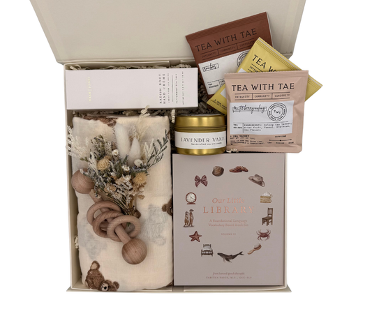 Gift set with tea, candle, and baby items in a box