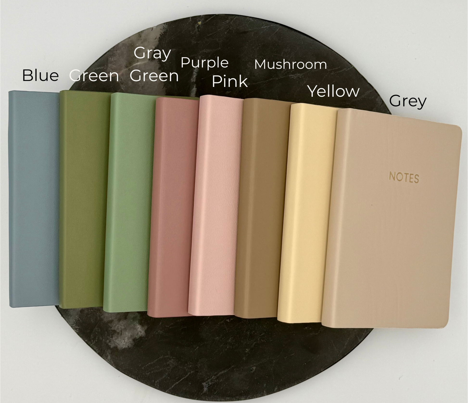 Set of notebooks in various colors on a marble surface