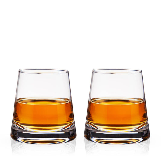 Two glasses of amber liquid on a white background